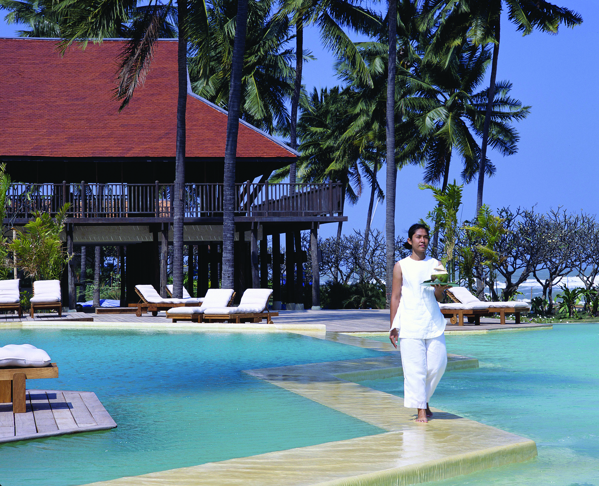 Evason Hua Hin Resort Thailand outdoor pool building with balcony overlooking outdoor pool loungers palm trees