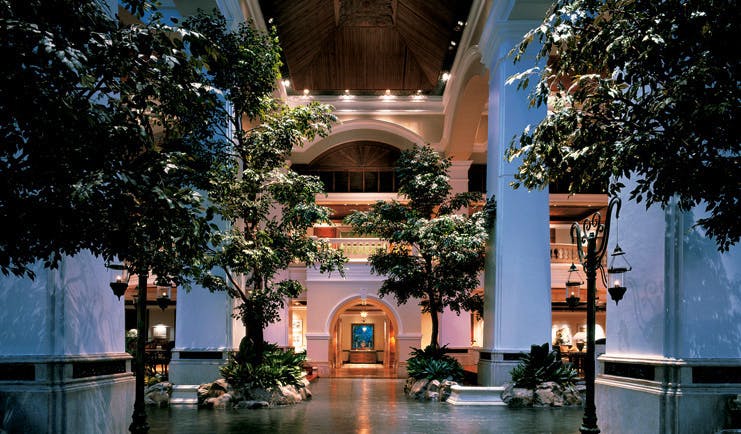 Grand Hyatt Erawan Bangkok Thailand atrium lobby trees columns night time