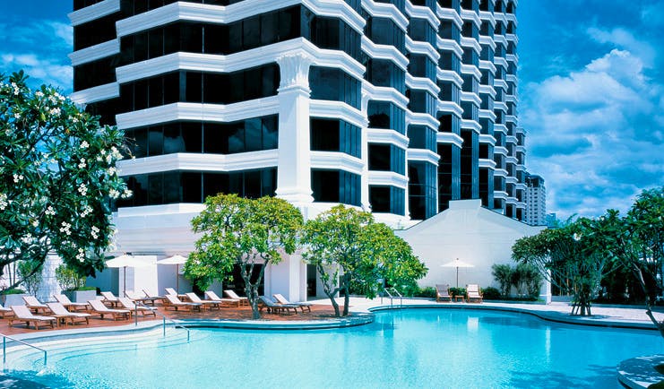 Grand Hyatt Erawan Bangkok Thailand outdoor pool loungers trees overlooked by hotel