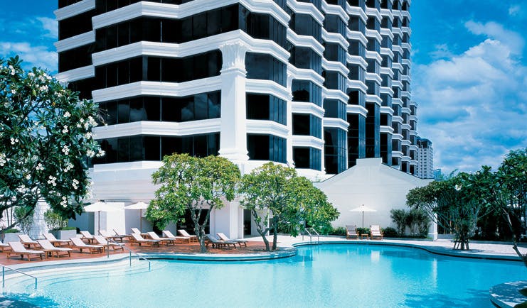 Grand Hyatt Erawan Bangkok Thailand outdoor pool loungers trees overlooked by hotel