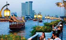 Mandarin Oriental Bangkok Thailand riverside terrace dining view of river traditional thai boats