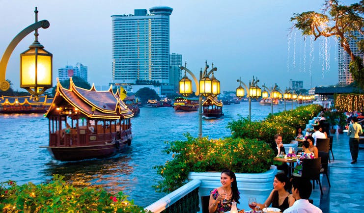 Mandarin Oriental Bangkok Thailand riverside terrace dining view of river traditional thai boats