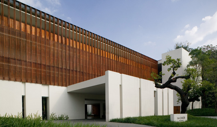 The Dhara Devi Thailand hotel entrance modern white and wood building lawns and tree 