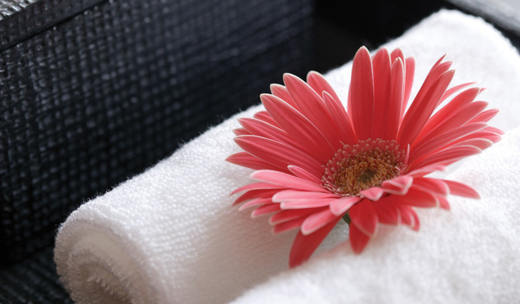 The Dhara Devi Thailand pink flower close up on white towels