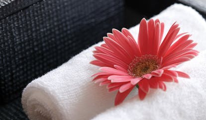 The Dhara Devi Thailand pink flower close up on white towels