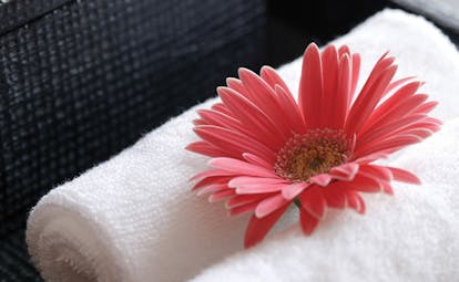The Dhara Devi Thailand pink flower close up on white towels