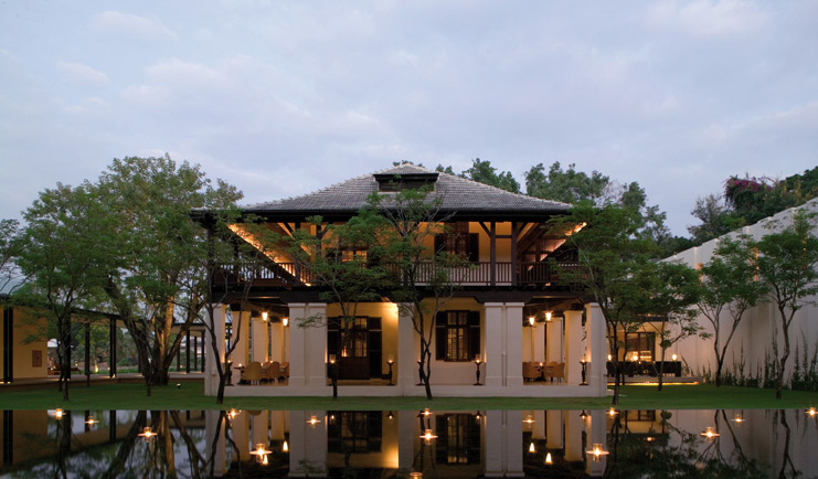 The Dhara Devi Thailand restaurant exterior white building with wooden roof pond floating candles 