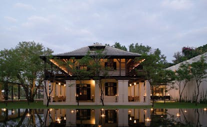 The Dhara Devi Thailand restaurant exterior white building with wooden roof pond floating candles 