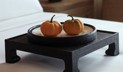 The Dhara Devi Thailand suite bedroom close up shots of miniature pumpkins on tray on bed