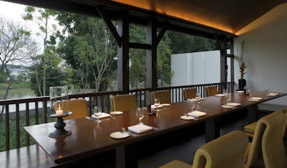 The Dhara Devi Thailand upper restaurant terrace covered outdoor dining area long table river view