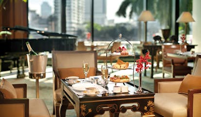The Peninsula Bangkok Thailand afternoon tea with champagne in lounge with grand piano and city views