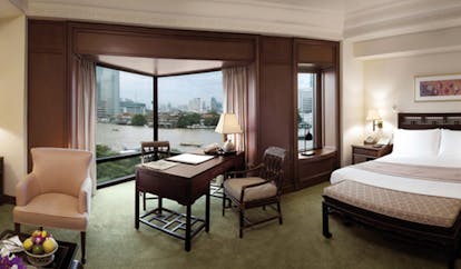The Peninsula Bangkok Thailand deluxe room bedroom sitting area large windows with river and city view