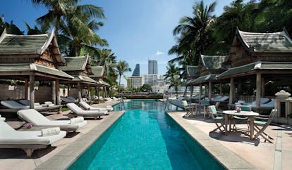 The Peninsula Bangkok Thailand outdoor swimming pool loungers pagodas city view