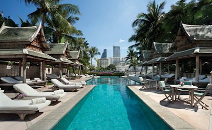 The Peninsula Bangkok Thailand outdoor swimming pool loungers pagodas city view