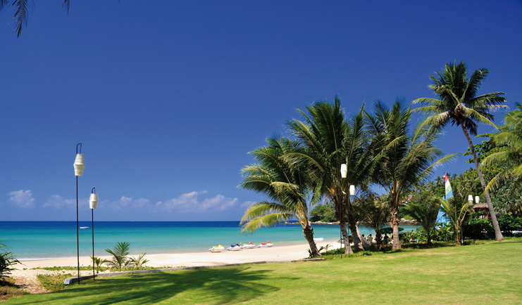 The Surin Phuket Thailand lawns palm trees leading to beach and boats
