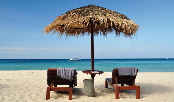 The Surin Phuket Thailand ocean view beach sun loungers thatched umbrellas yacht