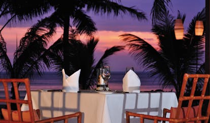 The Surin Phuket Thailand outdoor dining palm trees sunset