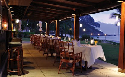 The Surin Phuket Thailand terrace restaurant overlooking lawns beach view at dusk