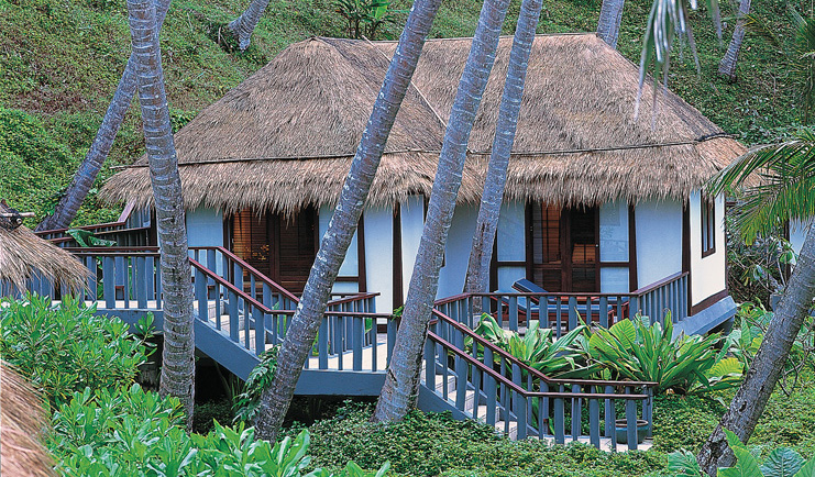 The Surin Phuket Thailand traditional bungalow thatched roof steps trees greenery