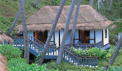 The Surin Phuket Thailand traditional bungalow thatched roof steps trees greenery