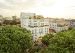Apricot Hotel exterior, grand hotel building, colonial style architecture, trees, city in background