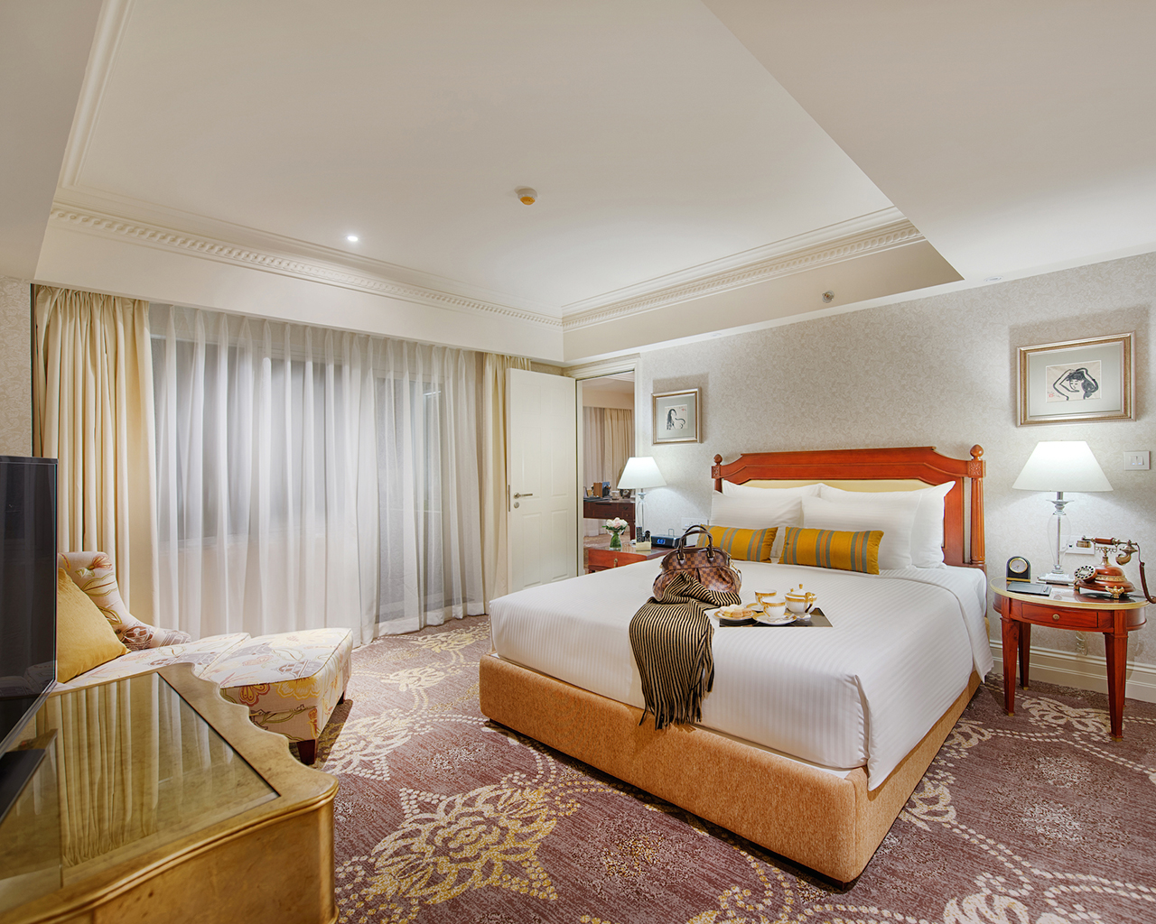 Apricot Hotel masterpiece suite, double bed, armchair, elegant decor, door leading to living room