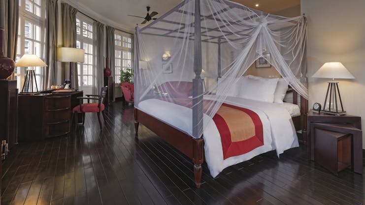 Azerai La Residence colonial suite, bed with canopy traditional decor, colonial style