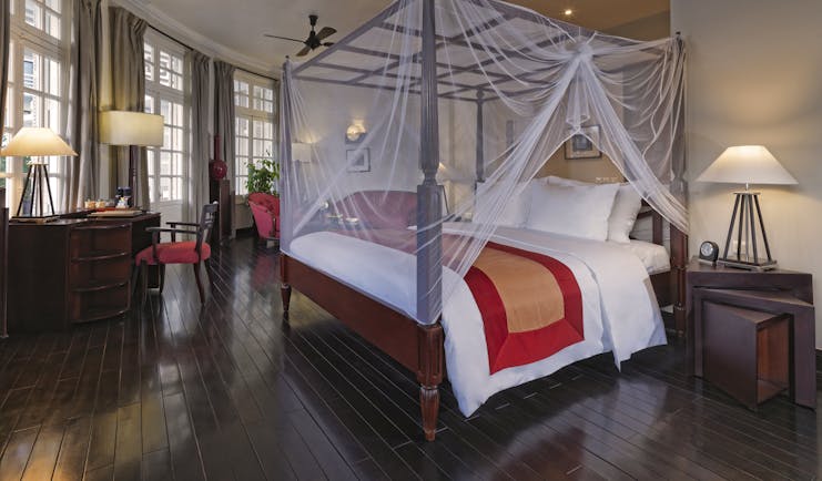 Azerai La Residence colonial suite, bed with canopy traditional decor, colonial style