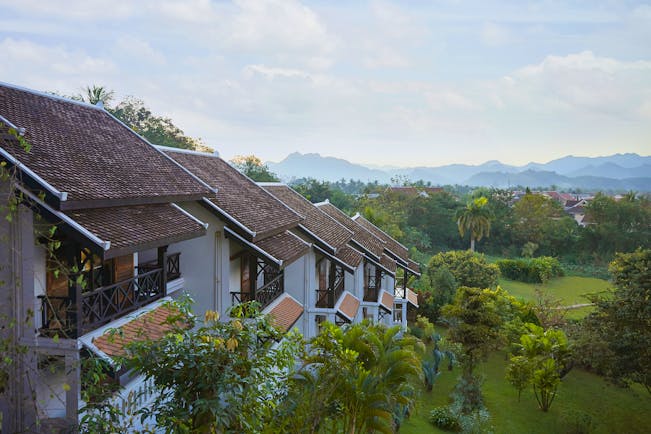 Belmond La Residence Phou Vao exterior, hotel buildings overlooking gardens, mountains in background