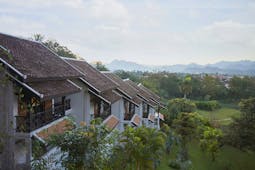 Belmond La Residence Phou Vao exterior, hotel buildings overlooking gardens, mountains in background