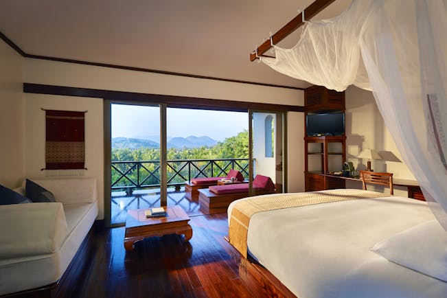 Belmond La Residence Phou Vao mountain room, bed with canopy, private balcony with mountain view