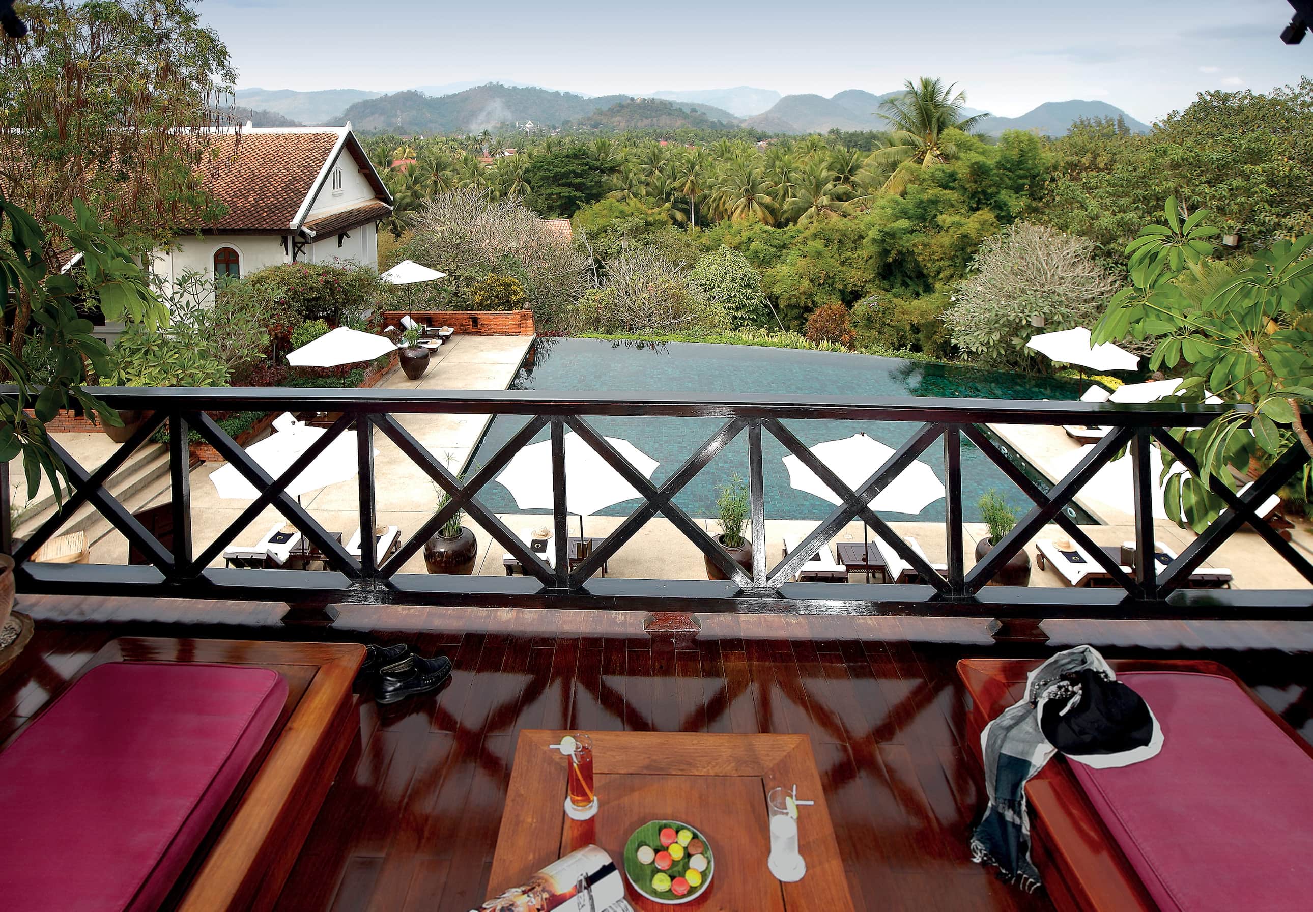 Belmond La Residence Phou Vao suite balcony, sun loungers, pool and mountain view