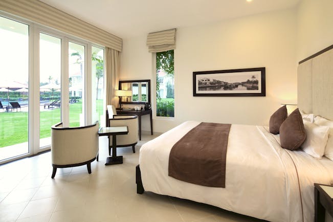Boutique Hoi An premier deluxe room, bed, bright modern decor, doors leading to garden
