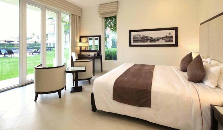 Boutique Hoi An premier deluxe room, bed, bright modern decor, doors leading to garden