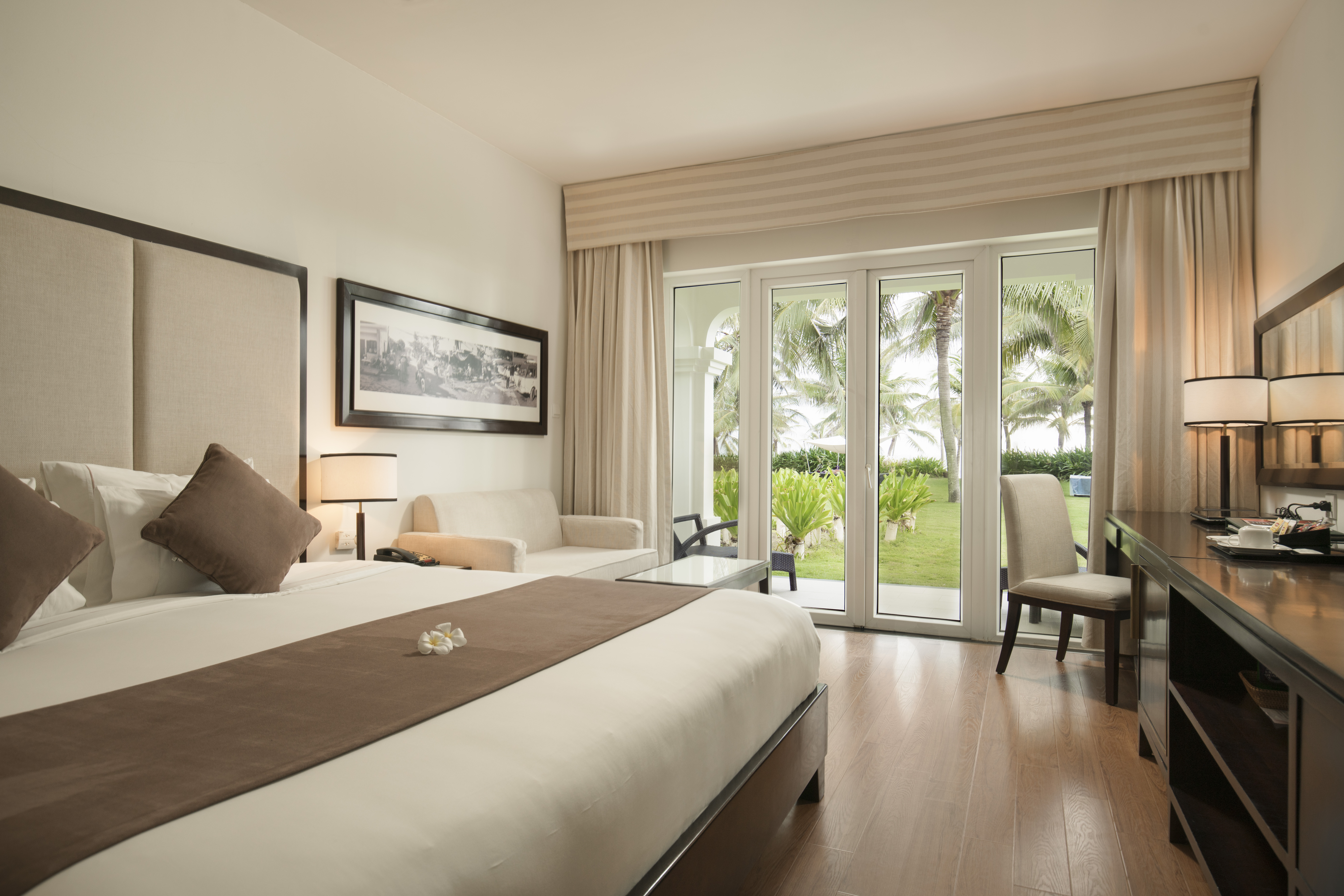 Boutique Hoi An villa bedroom, double bed, desk, modern decor, french doors leading to garden