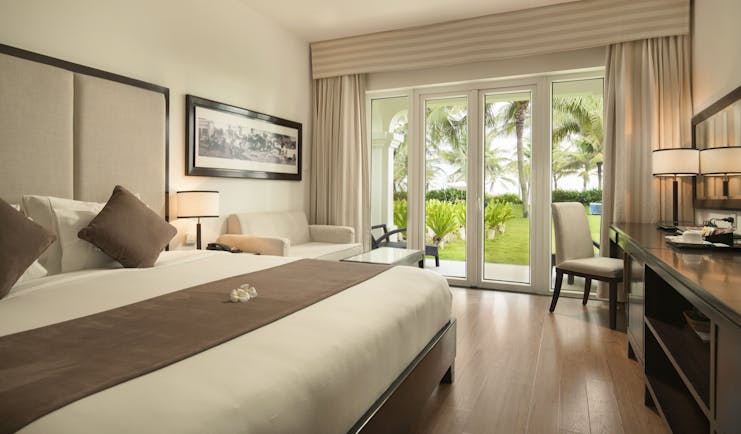 Boutique Hoi An villa bedroom, double bed, desk, modern decor, french doors leading to garden