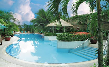 Caravelle Hotel Vietnam outdoor pool seating area loungers trees greenery