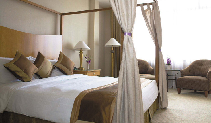 Caravelle Hotel Vietnam presidential suite bedroom four poster bed armchairs