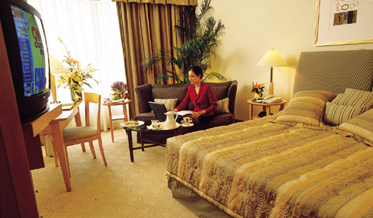 Caravelle Hotel Vietnam superior bedroom seating area and television