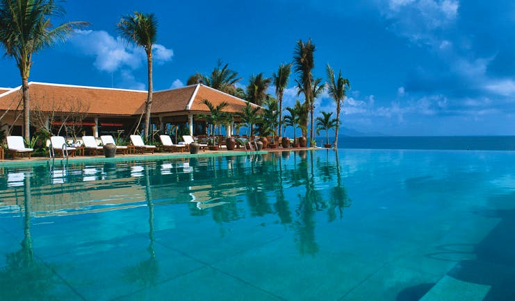 Evason Ana Mandara Resort Vietnam infinity pool lounger palm trees 