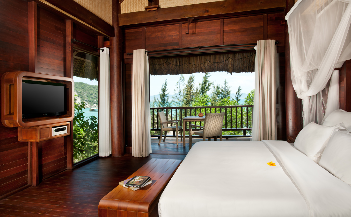 L'Ayla Ninh Van Bay hill rock villa bedroom, double bed with canopy, television, wood panel walls