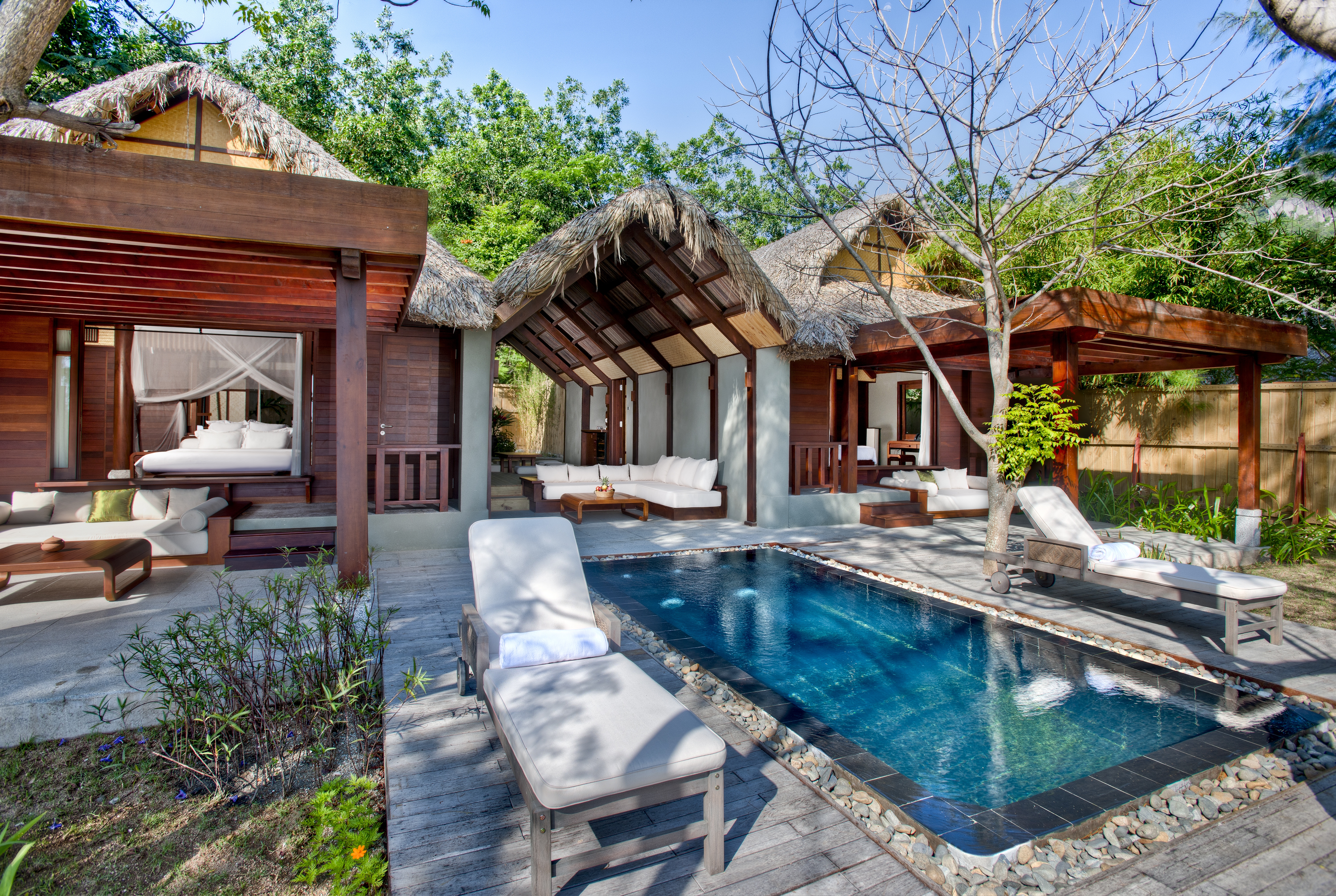 L'Ayla Ninh Van Bay lagoon villa exterior, pool, sun loungers, trees in background