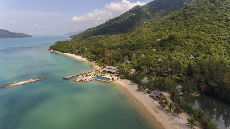 L'Ayla Ninh Van Bay resort, aerial shot of beachside resort with pool, villa nestled in tropical hillside
