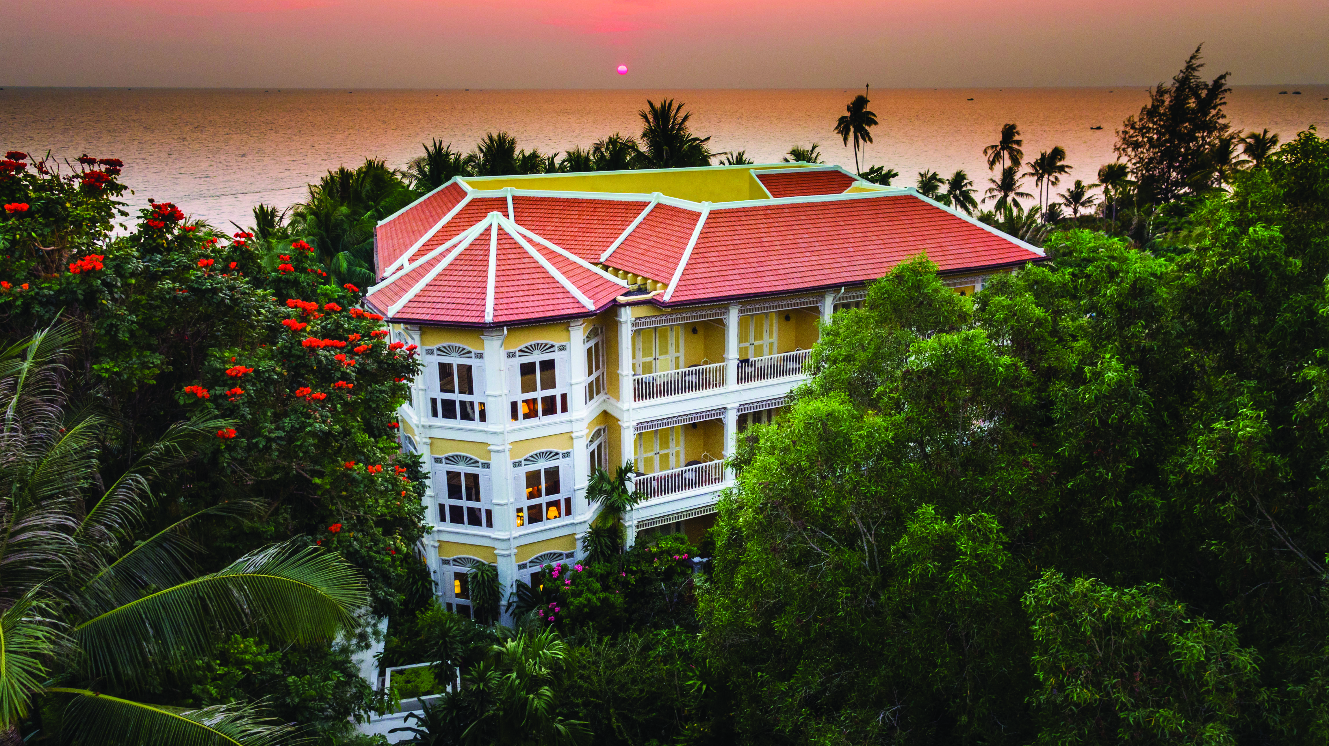 La Veranda Vietnam exterior hotel building surrounded by greenery ocean in background