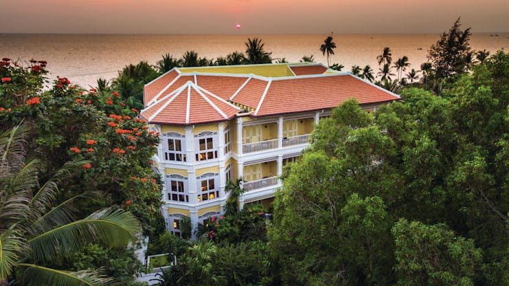 La Veranda Vietnam exterior hotel building surrounded by greenery ocean in background