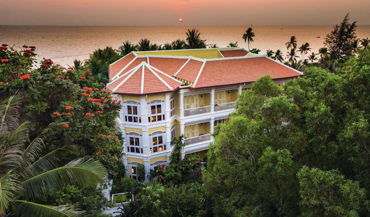 La Veranda Vietnam exterior hotel building surrounded by greenery ocean in background