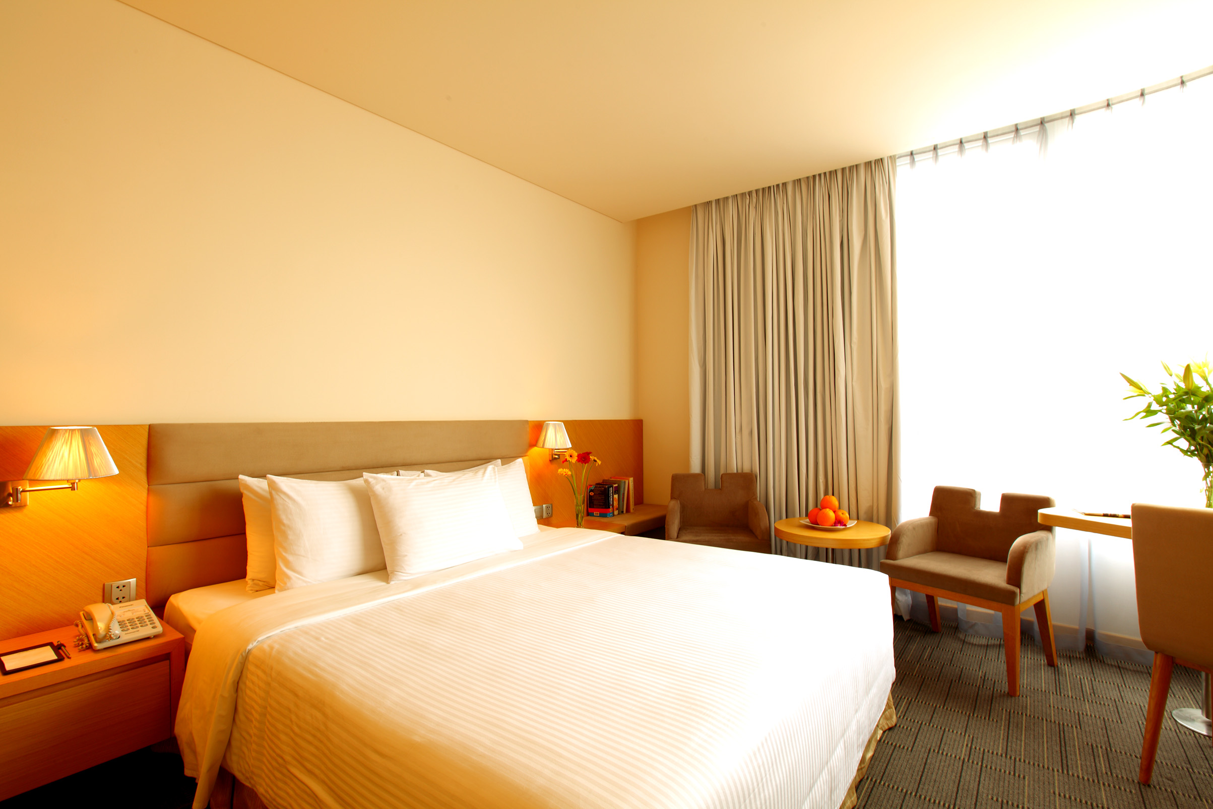 Liberty Central Saigon signature deluxe room, double bed, chairs, large windows, modern decor