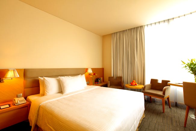 Liberty Central Saigon signature deluxe room, double bed, chairs, large windows, modern decor