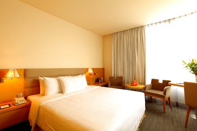 Liberty Central Saigon signature deluxe room, double bed, chairs, large windows, modern decor