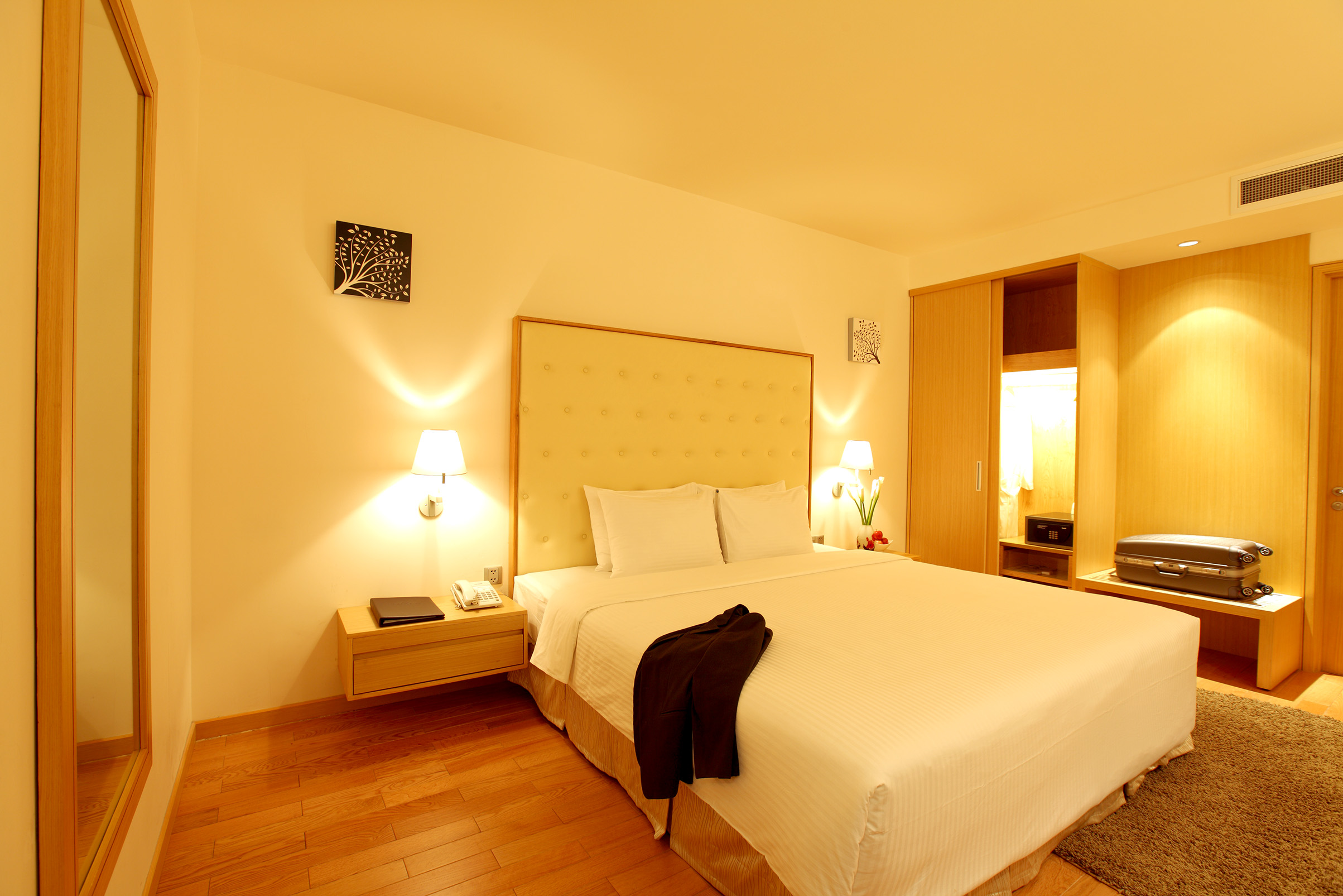 Liberty Central Saigon suite bedroom, double bed, large headboard, wardrobes, modern decor